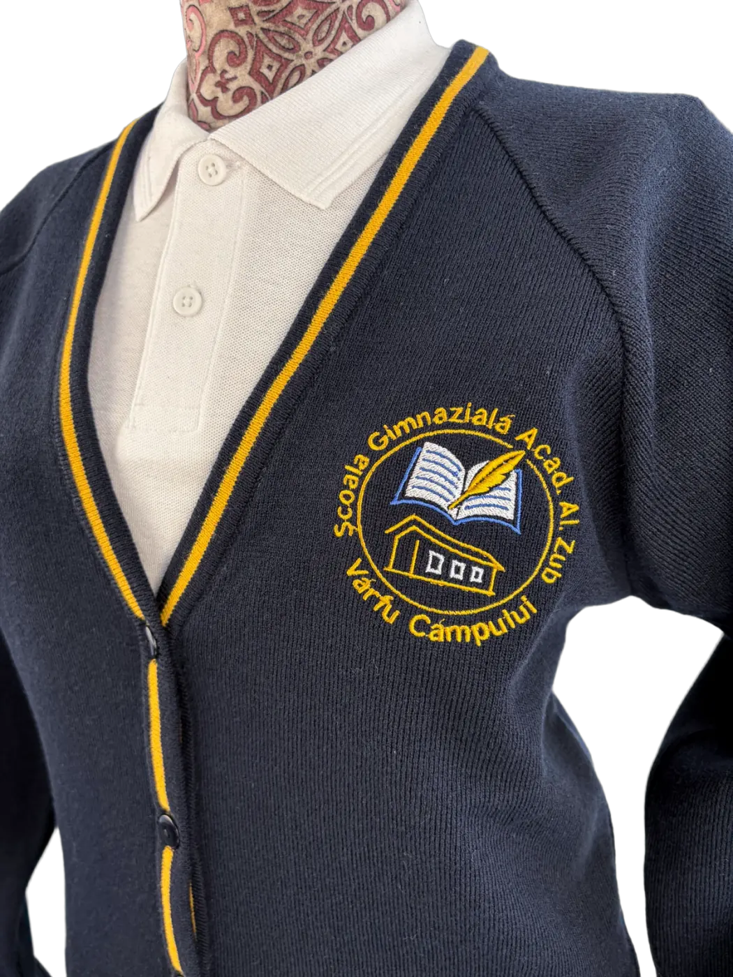 Close-up of embroidered crest on knitted cardigan