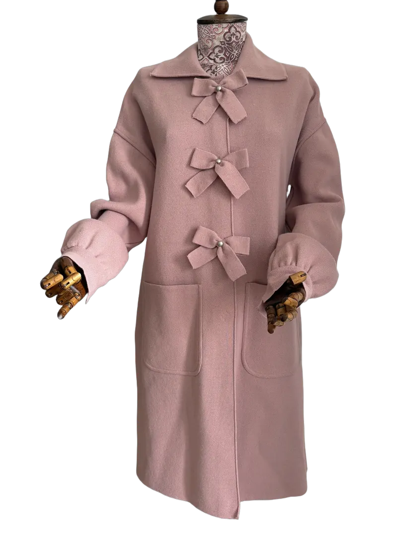 Pink knitted coat with bow fastenings